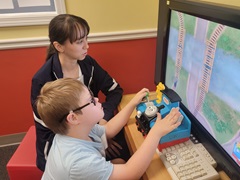 boy and volunteer play on computer